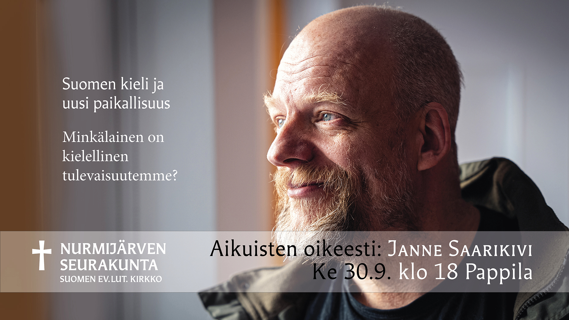 Hymyilevä Janne Saarikivi katsoo ikkunasta ulos. Hänellä on kokoparta.
