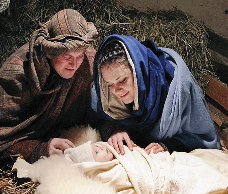Näytelmän mainoskuva, jossa Jeesus seimessä Mari ja Joosef ympärillään.