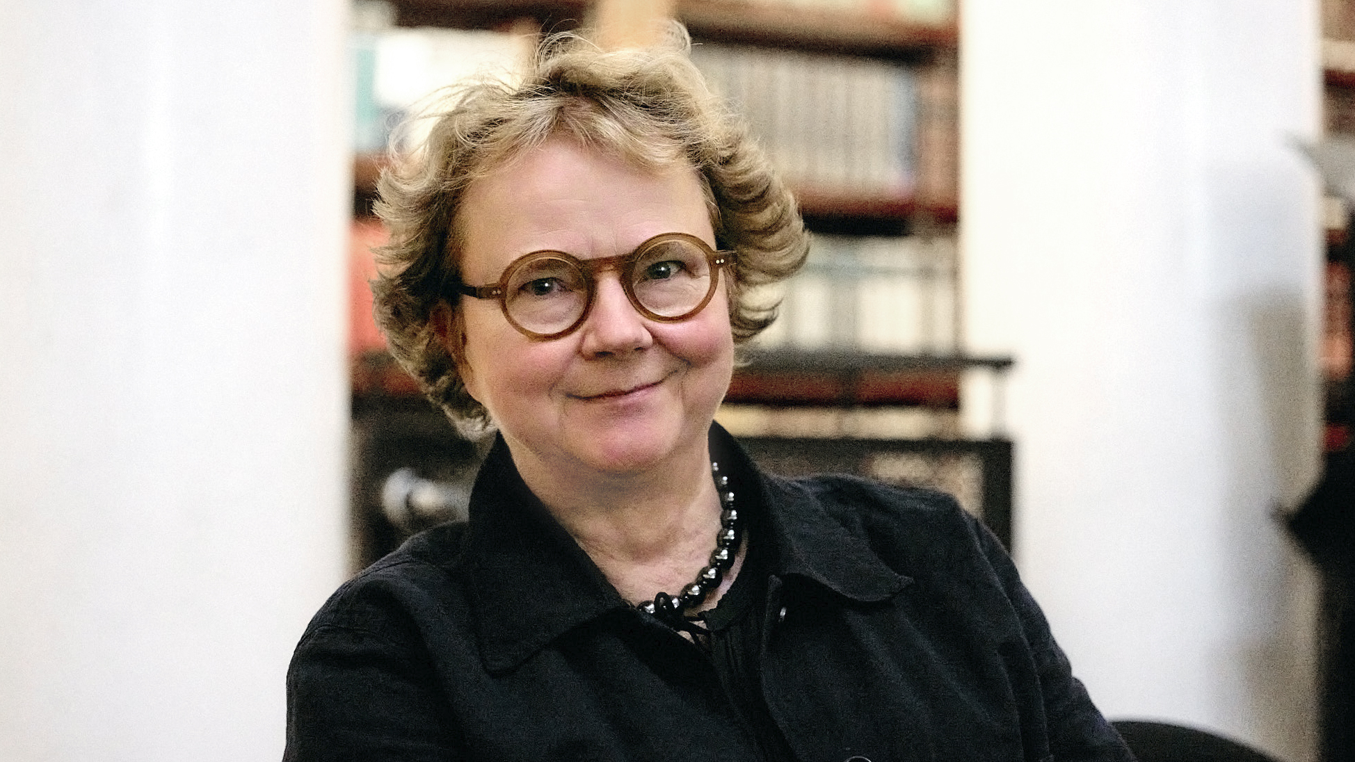Laura Kolbe hymyilee. Hänellä on pyöreät silmälasit.
