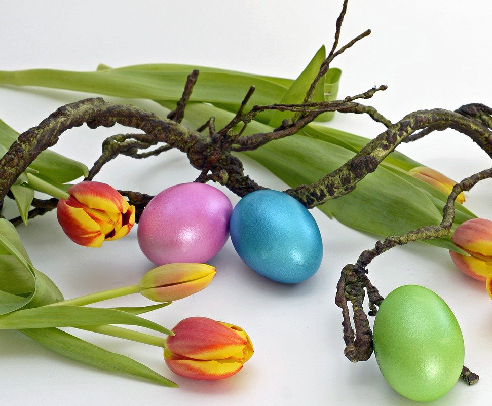 Asetelmassa värikkäitä tulppaaneja ja pääsiäismunia.