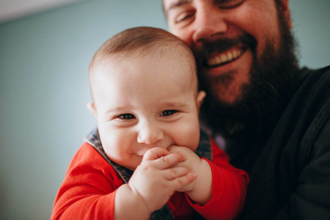 Vauva nauraa miehen sylissä