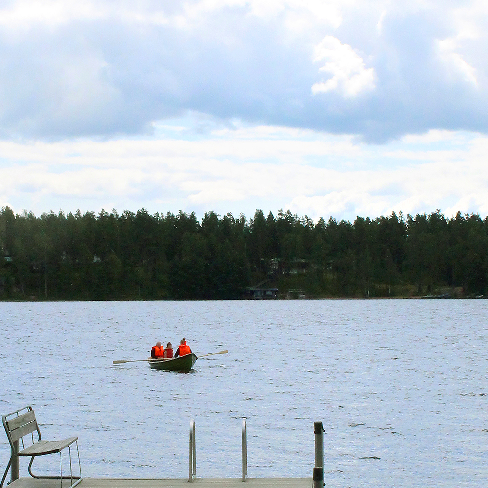 Kolme ihmistä soutelemassa Sääksjärvellä pelastusliivit yllään.
