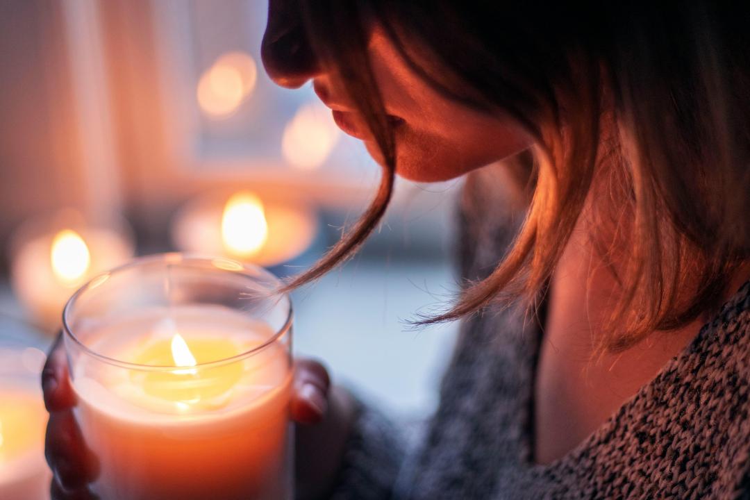 Nuori nainen on sytyttänyt kynttilän